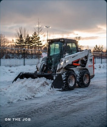 Skid steer clearing snow on the job